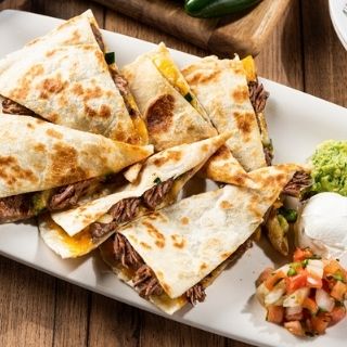 Brisket Quesadilla: Brisket, sautéed onions & pickled jalapeños. Served with jalapeño-BBQ sauce, guacamole, sour cream and pico de gallo.