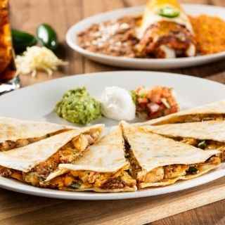 Fajita Quesadilla: Fajita chicken or steak with poblano, onion and roasted red-chile tomatillo salsa. Served with fresh guacamole, sour cream and pico de gallo.